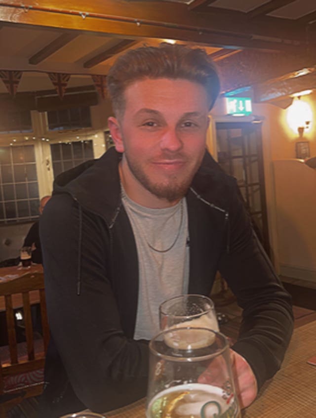 Joshua Clark sitting in a pub holding a pint of beer 