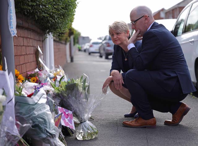 Home Secretary Yvette Cooper looks at floral tributes