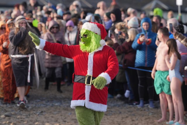 A swimmer dressed as the Grinch takes part in the annual New Year's Day charity swim on Bray seafront in County Wicklow.