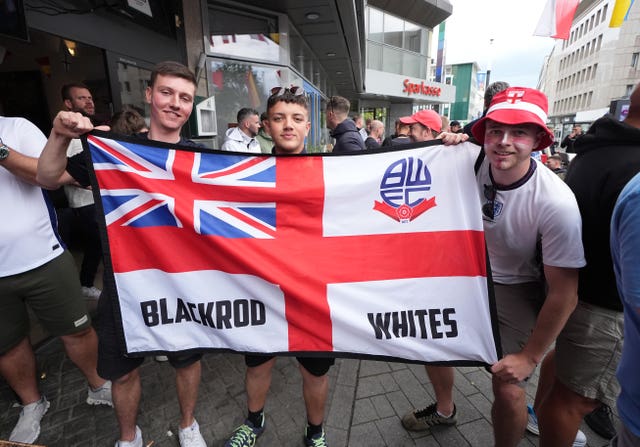 Fans smile as they unfurl an England flag