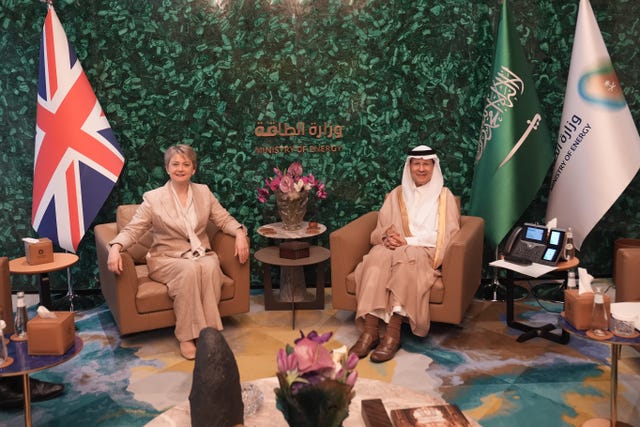 Yvette Cooper and Prince Abdulaziz bin Salman seated, with British and Saudi Arabian flags next to them