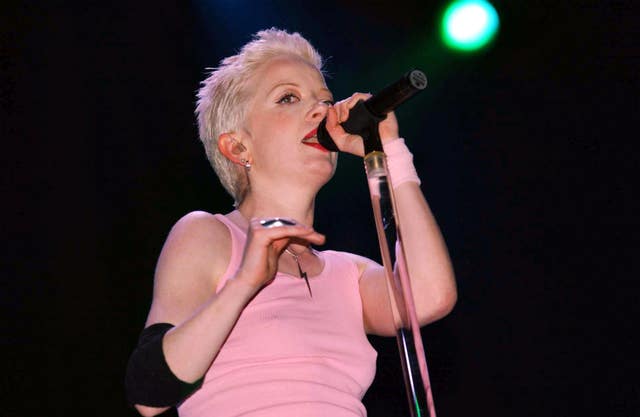 Shirley Manson of Garbage in a pink dress, sings into a microphone