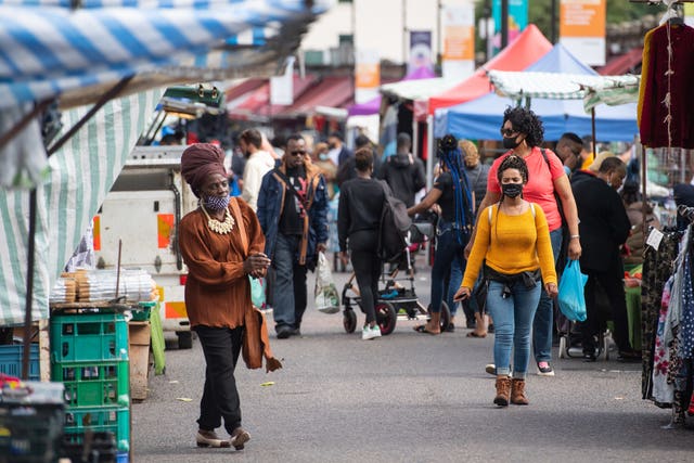 Shoppers wearing protective face masks at Ridley Road Market in Dalston, London (Dominic Lipinski/PA)