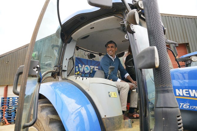 Rishi Sunak sits in a tractor 