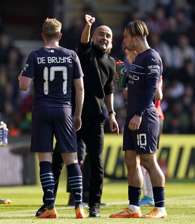 Manchester City manager Pep Guardiola (centre) speaks to Jack Grealish