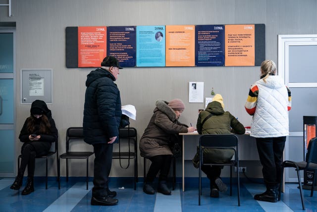 People wait to receive humanitarian aid including food and hygiene facilities for Ukrainians, at the Depaul International Day Centre in Kyiv (Aaron Chown/PA) 