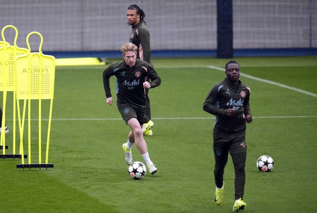 Kevin De Bruyne, centre, dribbles the ball in training with Manchester City