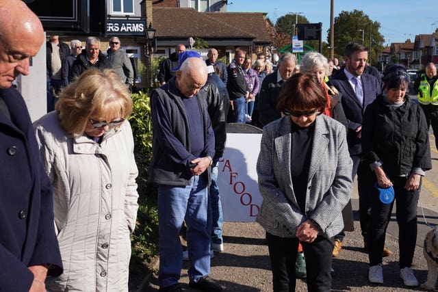 Shopkeepers and local residents observe a two-minute silence in memory of MP Sir David Amess 