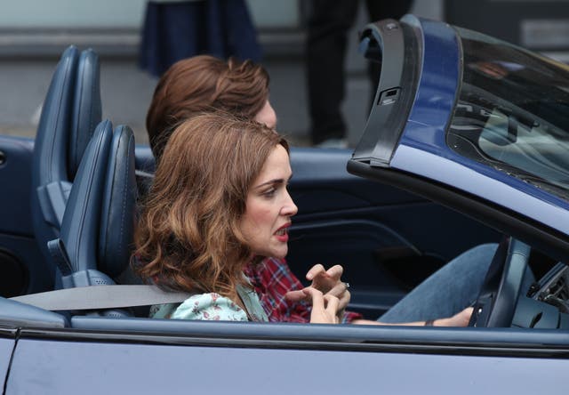 Rose Byrne and Domhnall Gleeson driving in an Aston Martin car