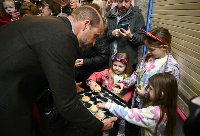 Children help themselves to some of William's cakes 