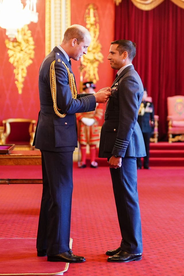 Group Captain Kevin Latchman, Royal Air Force, is decorated with the Air Force Cross by the Prince of Wales at Buckingham Palace 