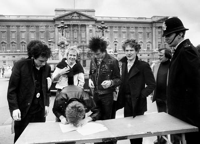 The group Sex Pistols, signing a new recording contract with A&M Records outside Buckingham Palace in London, (l/r) Johnny Rotten, Steve Jones, Paul Cook, bass player Sid Vicious and the group’s manager Malcolm McLaren (Archive/PA)