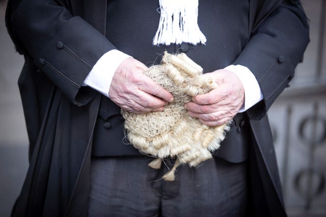 A judge holding a wig