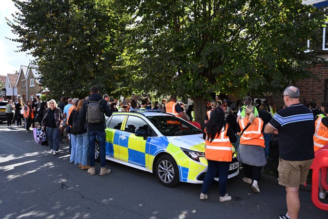 People standing round a police car