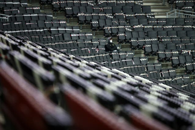 Rows of empty seats occupied by another lone ball boy at the MK Dons Stadium 