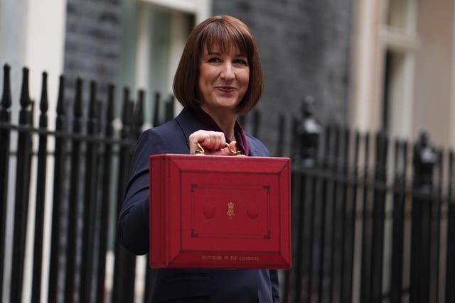 Rachel Reeves stands holding the red Budget day case