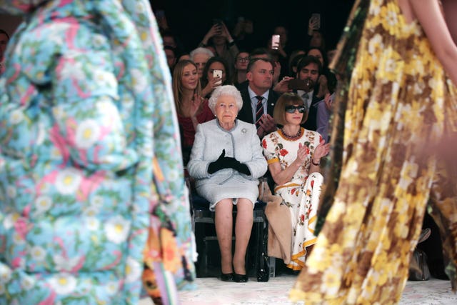 The Queen sitting next to Anna Wintour as they view Richard Quinn’s runway show at London Fashion Week