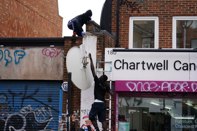 People removing a new howling wolf artwork by Banksy