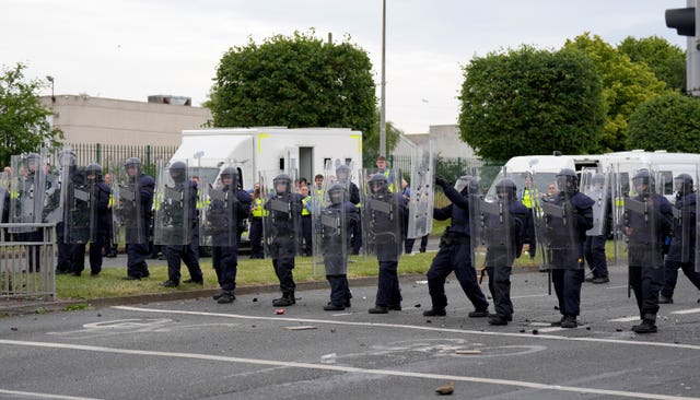 A line of gardai in a road with riot shields