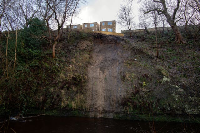 The back gardens of residential properties on Manchester Road, Slaithwaite, sit precariously near to the edge of a landslide on the banks of the River Colne near Huddersfield, West Yorkshire