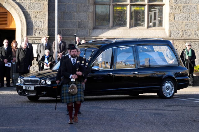 Piper walking in front of hearse