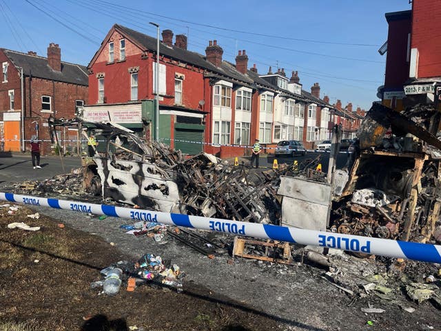 A burnt out car cordoned off with police tape in Harehills