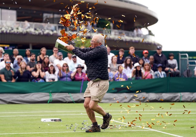 A Just Stop Oil protester interrupts the match during a first-set tie-break