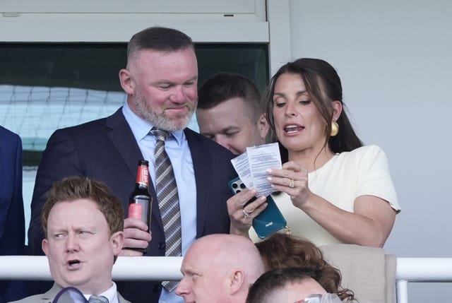 Wayne Rooney and Coleen Rooney in the grandstand during the William Hill Handicap Hurdle on Grand National Day of the Randox Grand National Festival 2026 at Aintree Racecourse