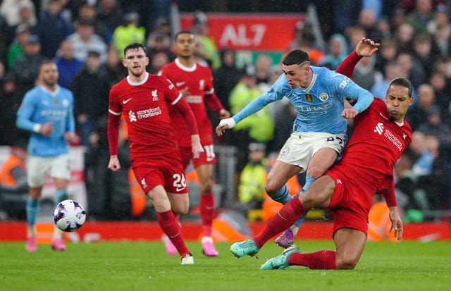Liverpool’s Virgil van Dijk challenges Manchester City’s Phil Foden (Peter Byrne/PA)