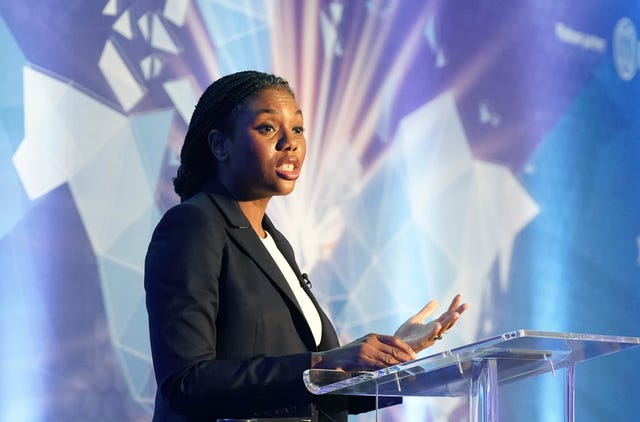 Kemi Badenoch stands at a lectern delivering a speech 