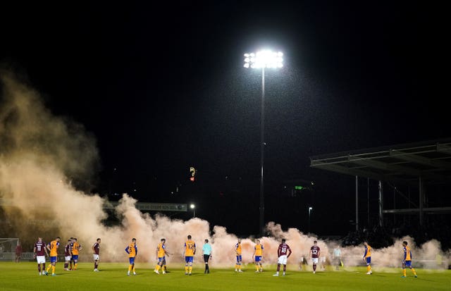 Smoke from a flare blows across the pitch at Sixfields