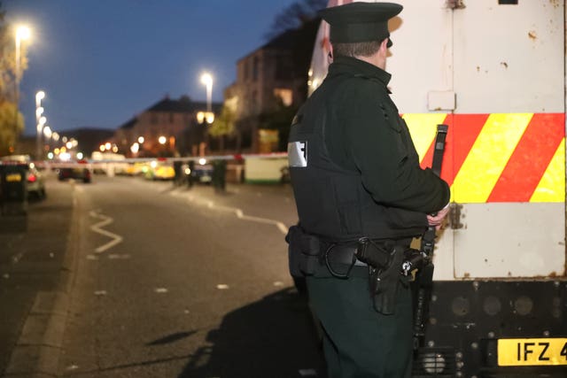 An armed police officer guards the cordon at the scene of a shooting lose to St Mary’s Grammar School, west Belfast