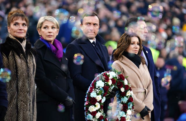 Former West Ham captain Mark Noble carries a wreath of flowers in tribute to David Gold