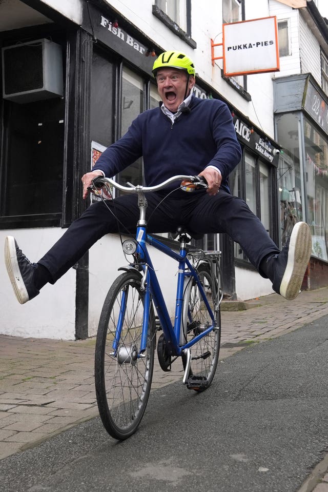Liberal Democrat leader Sir Ed Davey riding a bike in Knighton, Wales 