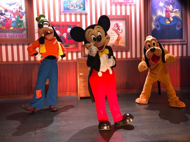 Mickey Mouse, flanked by Goofy and Pluto