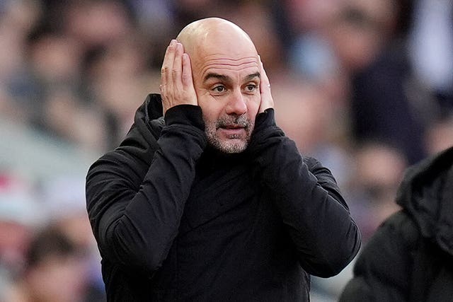 Pep Guardiola puts his hands on his head during a game