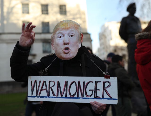 A protester wears a Donald Trump mask