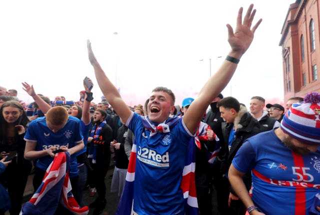 A Rangers fan celebrates outside Ibrox