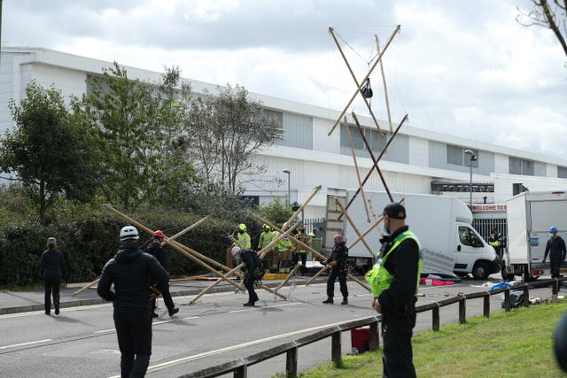 Emergency services dismantle the bamboo lock-ons used to block the road outside the Newsprinters printing works at Broxbourne, Hertfordshire
