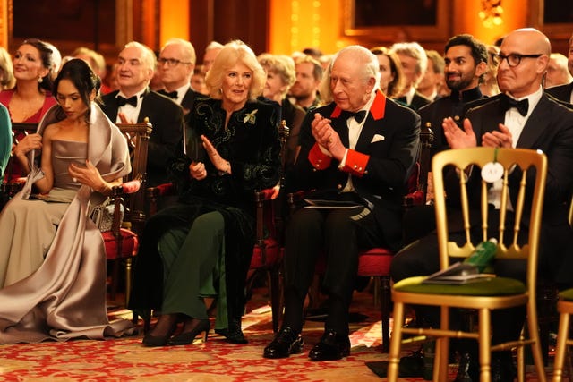 Charles and Camilla applauding as they sit in the audience