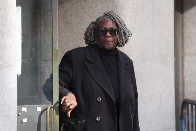 Janice Nix leaving court wearing sunglasses and dressed in a black coat