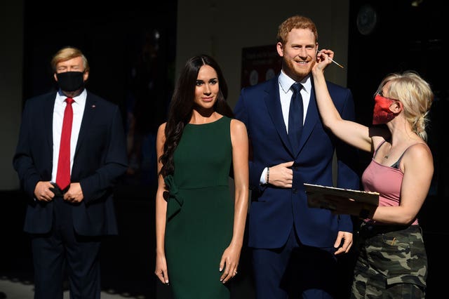 An artist puts the finishing touches the wax figures of the Duke and Duchess of Sussex, in the entrance line at Madame Tussaud’s in London (Kirsty O'Connor/PA)