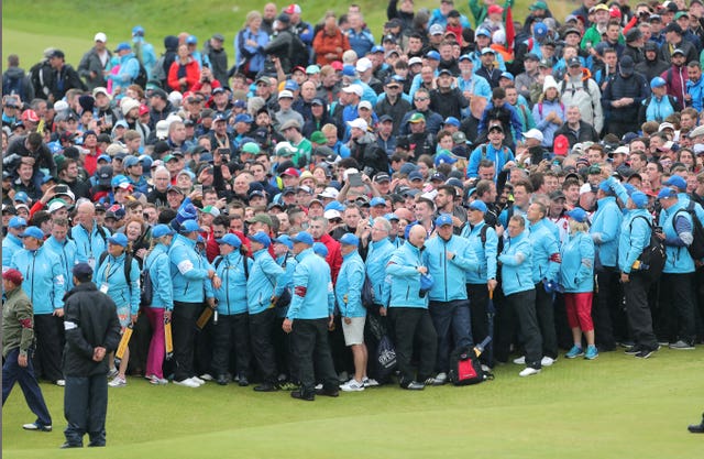 Large crowds gather around the 18th green