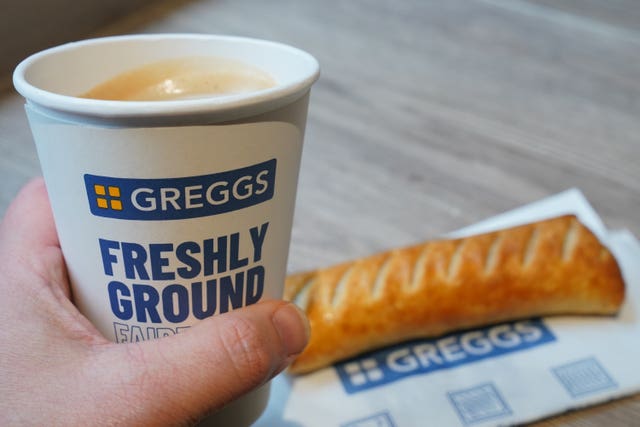 A cup of coffee and a sausage roll in a Greggs shop 