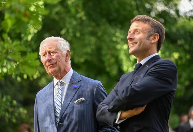 The King and Emmanuel Macron share a smile after planting a tree in the garden of the British ambassador’s residence in Paris to commemorate the state visit 