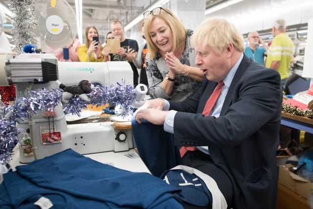 Prime Minister Boris Johnson uses a sewing machine during a visit to the John Smedley Mill in Matlock, Derbyshire