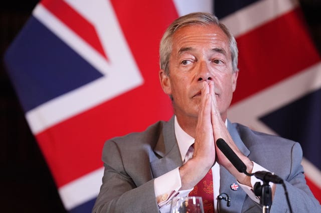 Nigel Farage sitting in front of a Union flag