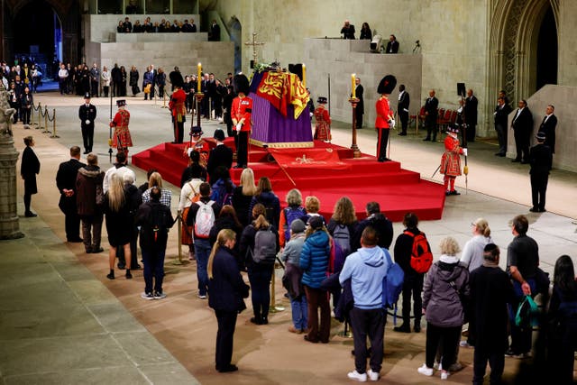Members of the public observe the national minute’s silence in memory of the Queen in Westminster Hall on Sunday evening