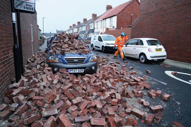 A man makes safe fallen masonry from a property, in Roker, Sunderland, after gusts of almost 100 miles per hour battered some areas of the UK during Storm Arwen in 2021 (Owen Humphreys/PA)