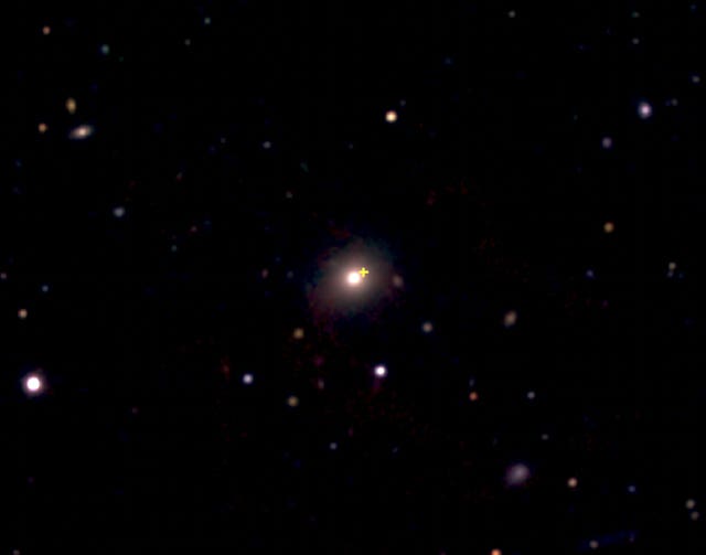 A distant red galaxy, centre, where a cosmic explosion occurred